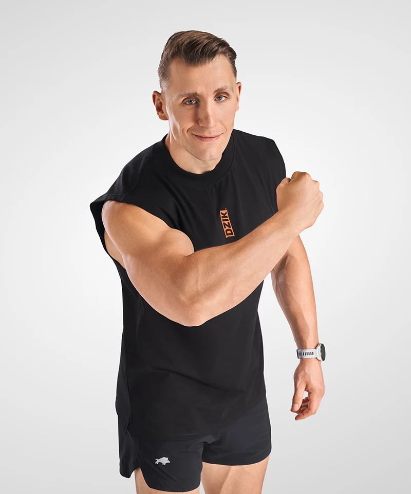 Profesjonalna fotografia mody w Warszawie - model w czarnej odzieży sportowej marki DZIK podczas sesji lookbook w studiu