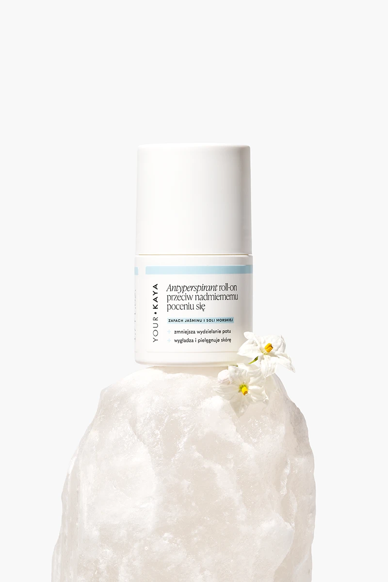 Stylizowana fotografia kosmetyków w Warszawie - antyperspirant na krysztale soli z kwiatami, koncepcja studia Packshothouse.