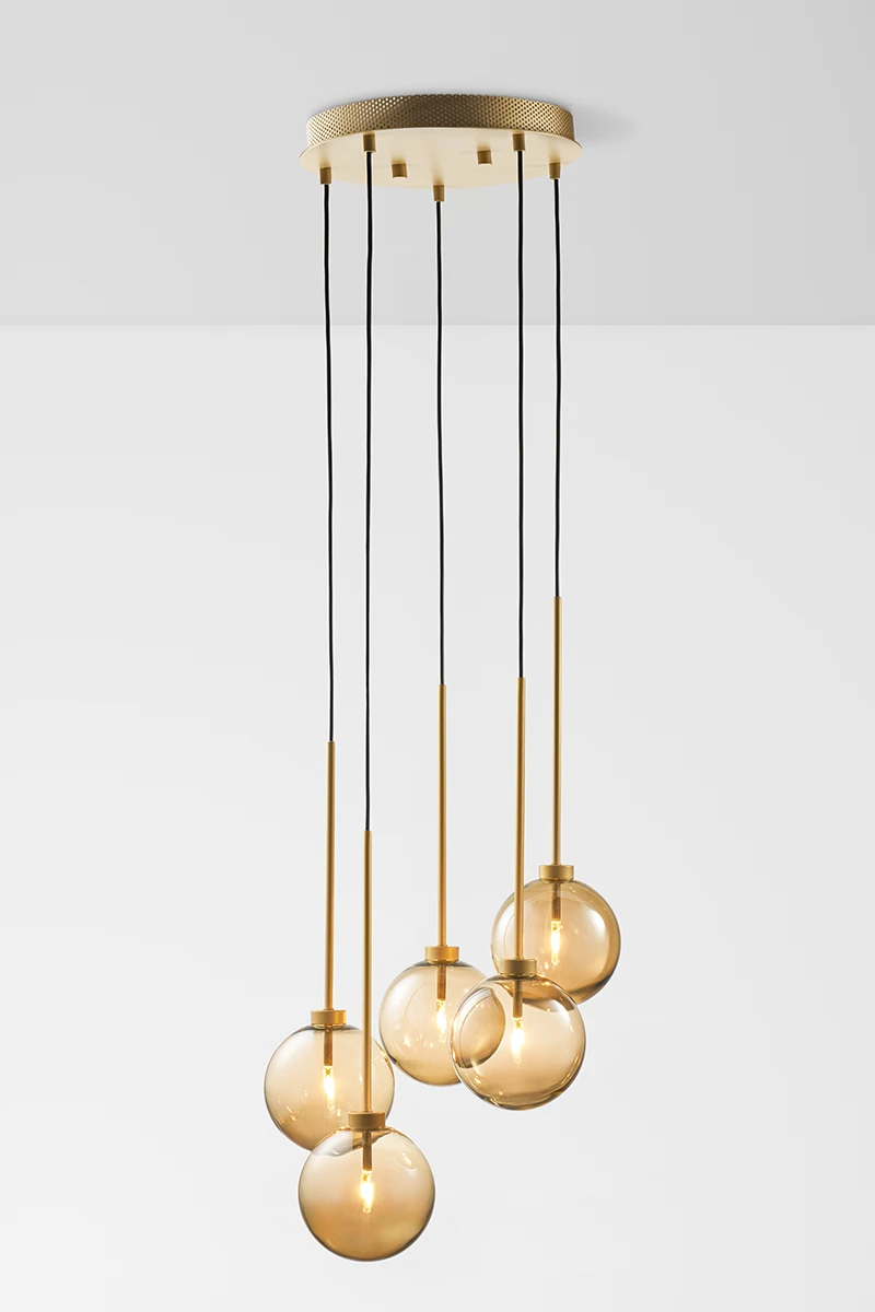 Profesjonalna fotografia oświetlenia w Warszawie - nowoczesna złota lampa wisząca ze szklanymi kulami, wykonana przez studio Packshothouse.
