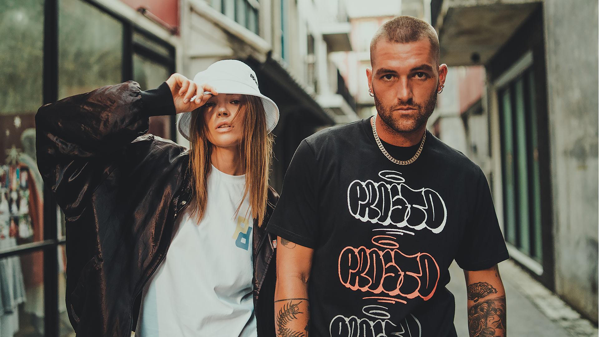 Sesja modowa streetwear w mieście, para modeli w stylizacjach urban lifestyle podczas zdjęć lookbookowych